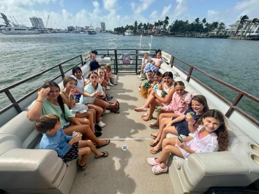 Group cruising aboard the Breezy Tiki pontoon with the Fort Lauderdale skyline behind